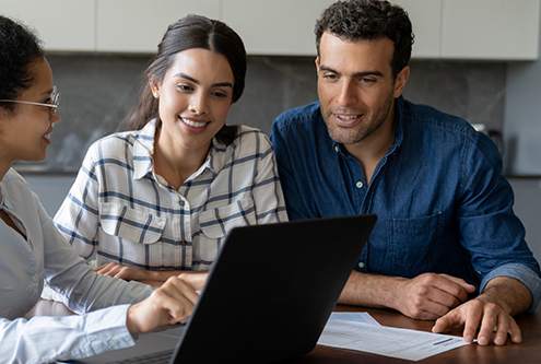 adult couple sitting at a table with a banker financial meeting